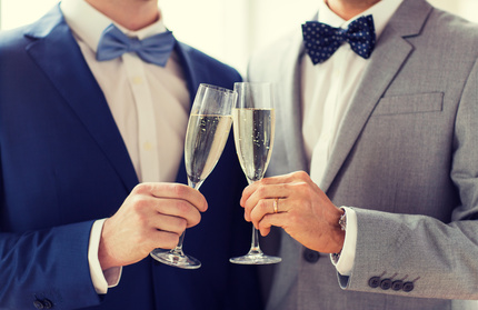 Homosexuelles Paar Zwei Männer im Anzug stoßen mit Sektgläsern an